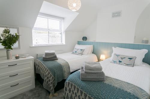 a bedroom with two beds and a dresser at 45 Bryn Lane in Beaumaris