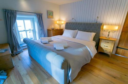 ein Schlafzimmer mit einem großen Bett mit zwei Handtüchern darauf in der Unterkunft 10 Bunkers Hill in Beaumaris