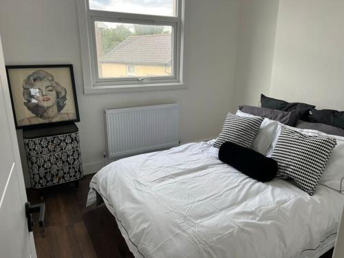 a bedroom with a white bed and a window at Forte circle, luxury apartments in South Norwood