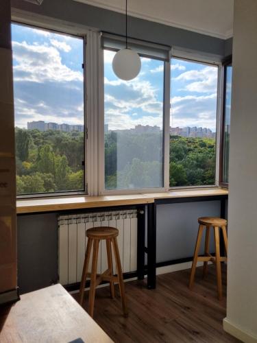 a room with two stools and two windows with a view at Park Loft, Calea Iesilor 67 in Chişinău