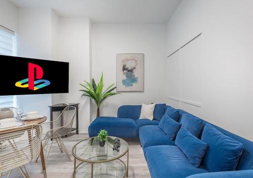 a living room with a blue couch and a table at Luxurious 3BD Apt in heart of downtown 5 min walk to Bell Center in Montréal