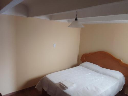 Dormitorio pequeño con cama con cabecero de madera en ENECO en San Martín