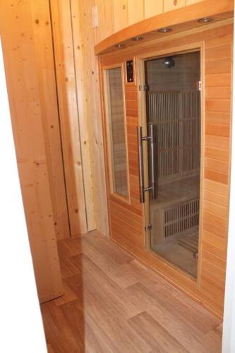une chambre avec une grande porte en verre dans une cabine dans l'établissement Gite les grèves : 15 pers, 300m de la mer + sauna, à Saint-Quay-Portrieux