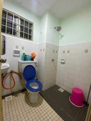 a bathroom with a blue toilet and a sink at Seri Kasturi Apartment in Puchong