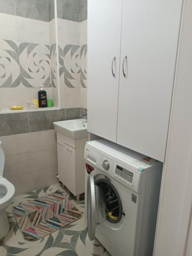 a kitchen with a washing machine in a bathroom at Эко дом in Astana