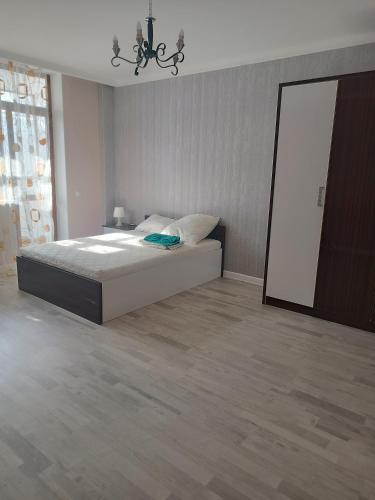 a bedroom with a large bed and a mirror at Эко дом in Astana
