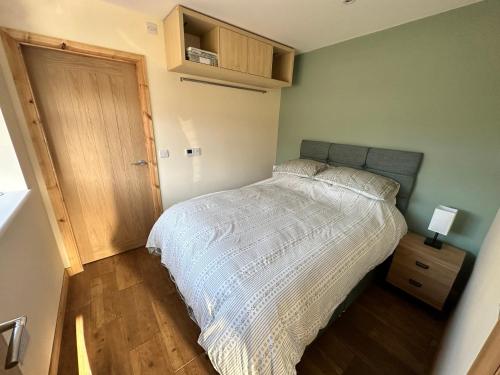 a bedroom with a bed with a white comforter at Seashell Cottage - Dog friendly 1 bed cottage close to the sea in Hornsea