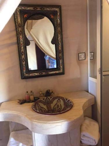 a bathroom with a sink and a mirror at Merzouga luxury magic nights in Merzouga