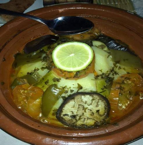 a plate of food with vegetables and a lemon on it at Merzouga luxury magic nights in Merzouga