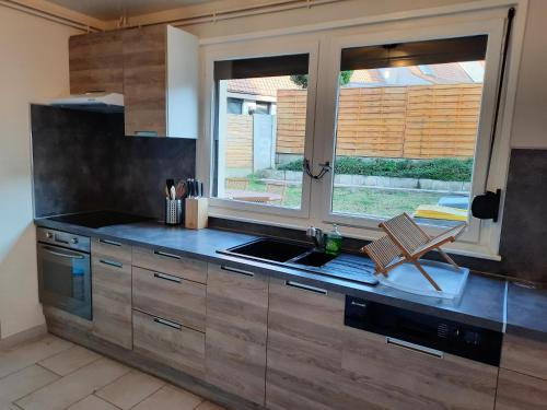 d'une cuisine avec un comptoir, un évier et une fenêtre. dans l'établissement Charmante maison 8 personnes à 2 pas de Wimereux, à Wimille