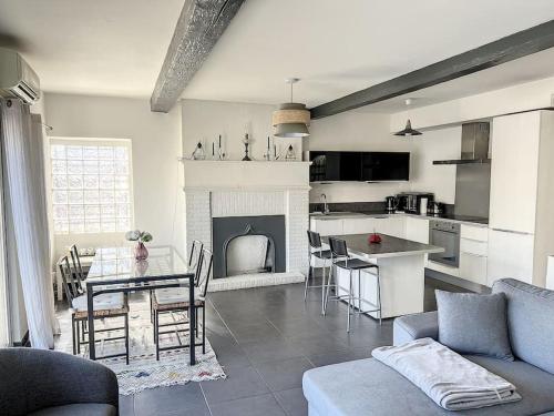 Il dispose d'une cuisine et d'un salon avec une cheminée et une table. dans l'établissement Très Agréable T2 - Lumineux-Toit Terrasse-Centre, à Marseille