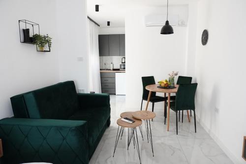a living room with a green couch and a table at "Handmade" Apartment in Niš