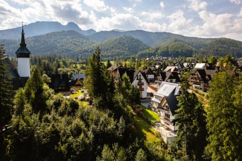 a town in the mountains with a church tower at Apartamenty Blisko TATR Zakopane in Zakopane