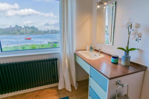 Un baño con lavabo y ventana. en Eigionfa, en Menai Bridge