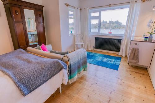 Un dormitorio con dos camas y una gran ventana. en Eigionfa, en Menai Bridge