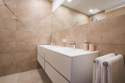 La salle de bains est pourvue d'un lavabo et d'un miroir. dans l'établissement Apartments Schöneben, à Ulrichsberg