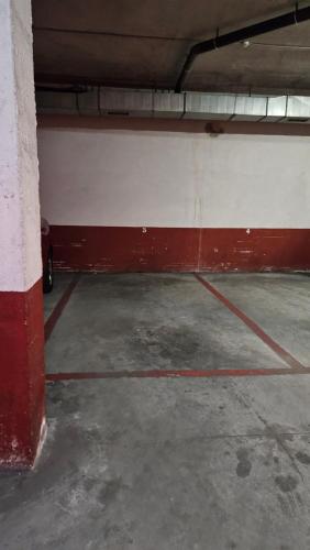 un garaje vacío con una pared roja y blanca en Aires de Pontevedra, en Pontevedra