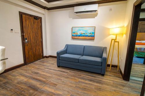 a living room with a blue couch in a room at Sago Palm Hotel in Ocho Rios