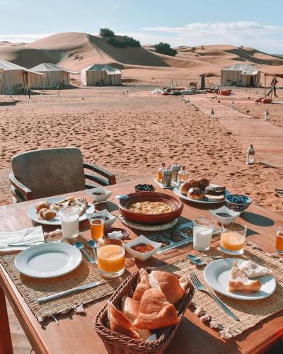 a table with food and bread on the beach at Magic Carpet camp in Merzouga