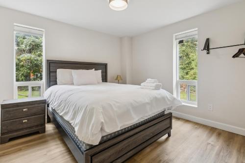 a white bedroom with a large bed and two windows at Blue View 9 Vintage Tyrolean Chalet 84152 in Blue Mountains