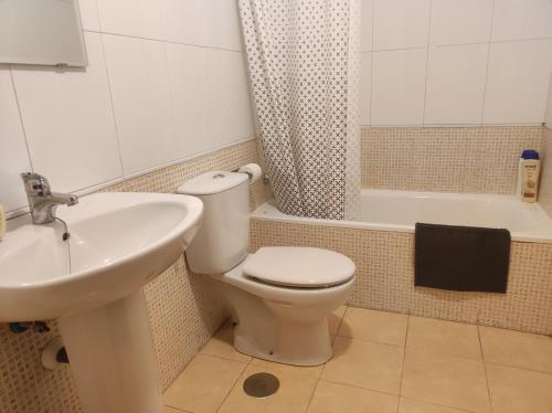 een badkamer met een toilet, een wastafel en een bad bij Precioso Dúplex con terraza Vut 47-91 