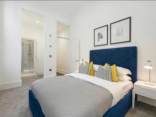 a large bedroom with a blue and white bed at Mr Charing in London