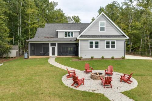a yard with red chairs and a house at Spacious Lake Sinclair Vacation Rental with Dock! in Resseaus Crossroads