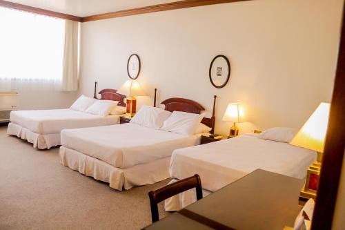 a hotel room with two beds and a table at Nobile Suites Excelsior Asuncion in Asuncion