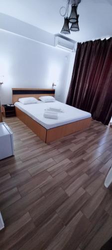 a bedroom with a large bed and a wooden floor at Hotel Blue Sky Resort in Eforie Nord