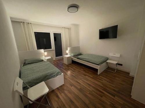 a room with two beds and a flat screen tv at City Apartment Lux Bremen in Bremen