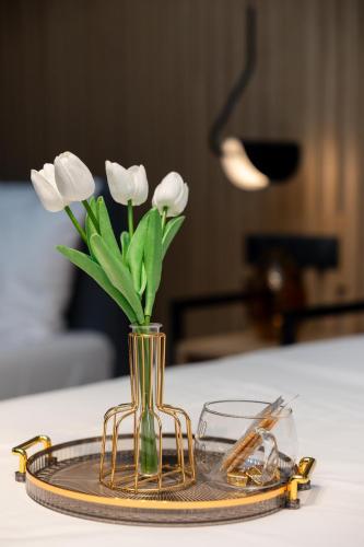 a vase with white flowers in it on a table at Valaoritou 3 Luxury Rooms in Thessaloniki