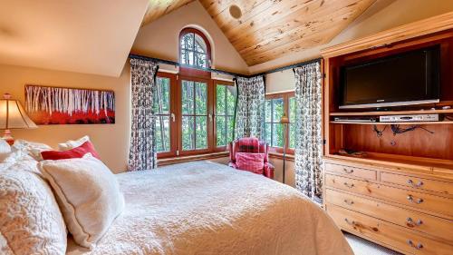 een slaapkamer met een bed en een flatscreen-tv bij Cypress Mountain Chalet in Breckenridge