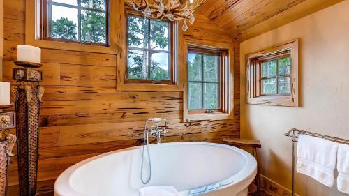 een badkamer met een bad in een blokhut bij Cypress Mountain Chalet in Breckenridge