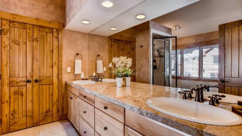 un bagno con due lavandini e un grande specchio di Bystone Villa Retreat a Breckenridge