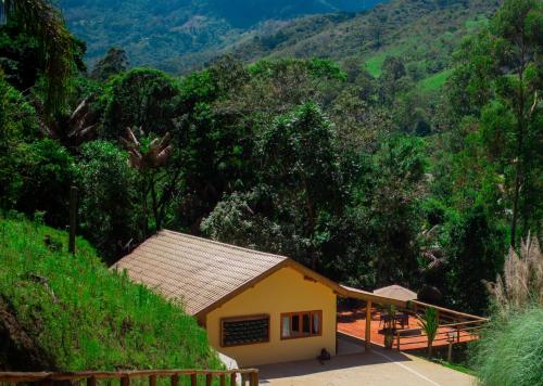 聖安東尼奧－杜皮尼亞爾的住宿－Go Organic Club - Santo Antônio do Pinhal SP, Brasil，山中的一个黄色小房子