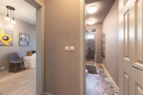 a hallway with a door leading to a bathroom with a shower at Primorski Residence Apartment in Varna City