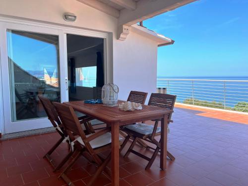 un tavolo in legno e sedie sul balcone. di TITINO stupendo appartamento in villa fronte Mare - Golfo dell'Asinara - Internet Free a Codaruina