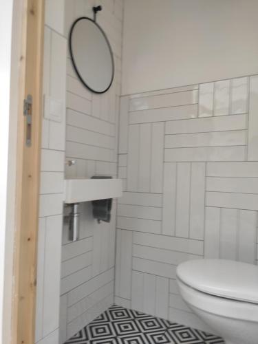 une salle de bain avec des toilettes blanches et un miroir dans l'établissement La Waide, à Amiens