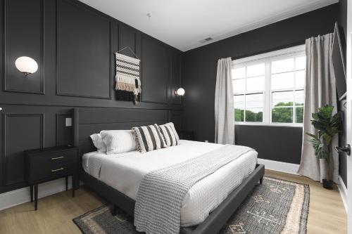Un dormitorio negro con una cama y una ventana. en Condo Near Downtown Broadway & Stadium - Free Parking, en Nashville