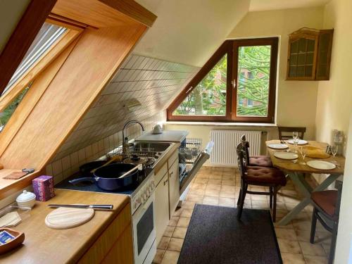 a kitchen with a sink and a stove and a table at Gartenblick-Oase: Obergeschosswohnung in Hamburg in Hamburg