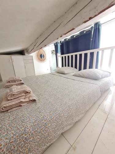 Cette chambre comprend un grand lit et des rideaux bleus. dans l'établissement La tour de gais, à Sète