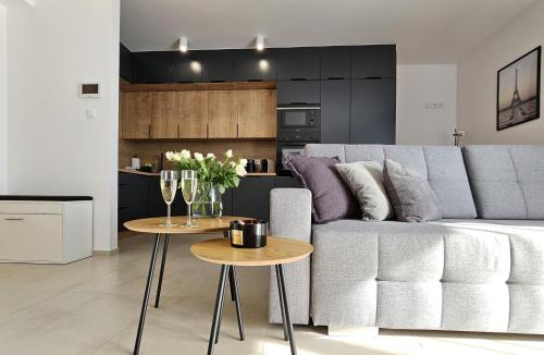 ein Wohnzimmer mit einem Sofa und 2 Tischen in der Unterkunft URBAN APARTMENTS Premium DOWNTOWN Opolska 10 No 77A with GARAGE in Kattowitz