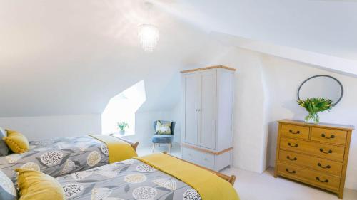 1 dormitorio con 2 camas y vestidor en Gower Cottage en Beaumaris