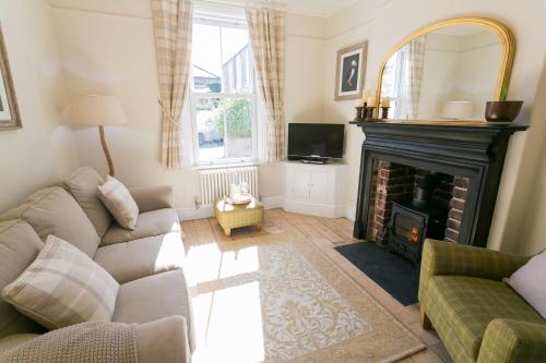 a living room with a couch and a fireplace at Glan Y Mor in Beaumaris