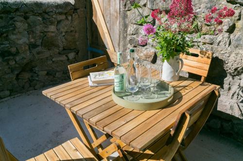 a wooden table with a vase of flowers on it at Glan Y Mor in Beaumaris