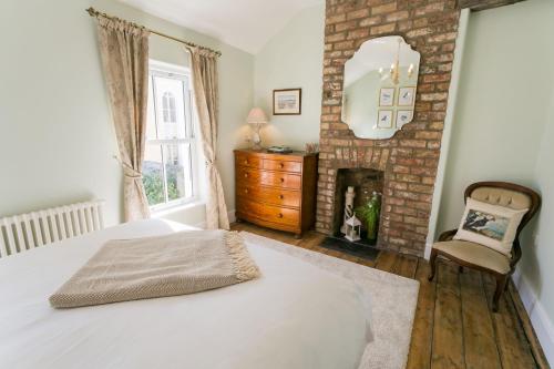 a bedroom with a bed and a fireplace at Glan Y Mor in Beaumaris