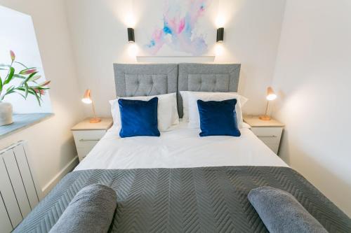 a bedroom with a large bed with blue pillows at Gwel y Fenai in Penmon