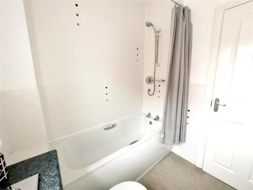 uma casa de banho com banheira e chuveiro em Cheerful two-bedroom townhouse near Leeds and York em Leeds