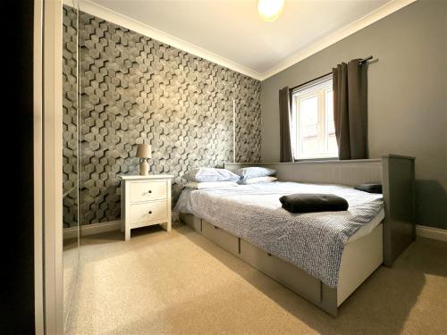 a bedroom with a bed and a glass wall at Cheerful two-bedroom townhouse near Leeds and York in Leeds