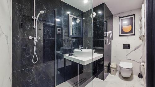 uma casa de banho em preto e branco com um lavatório e um chuveiro em Resort Solny w Kołobrzegu Apartament A031 em Kolobrzeg